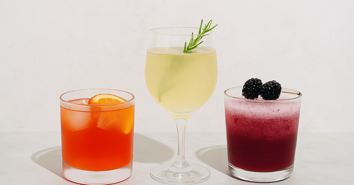 Colorful non-alcoholic mocktails with fruit and herbal garnishes on minimalist background, probiotic and functional drink alternatives for sober-curious lifestyle and mindful drinking