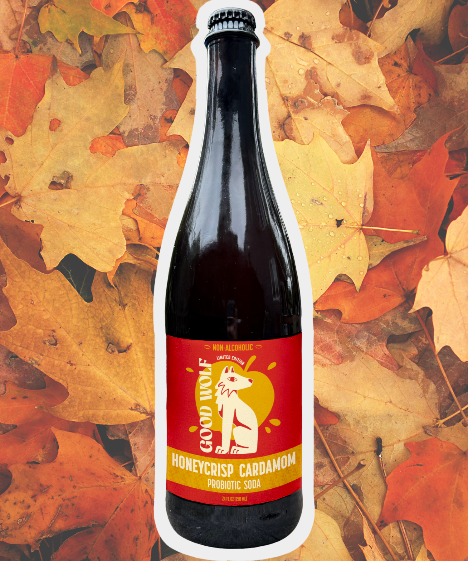 750ml glass Bottle of Good Wolf Honeycrisp Cardamom soda on a background of autumn leaves