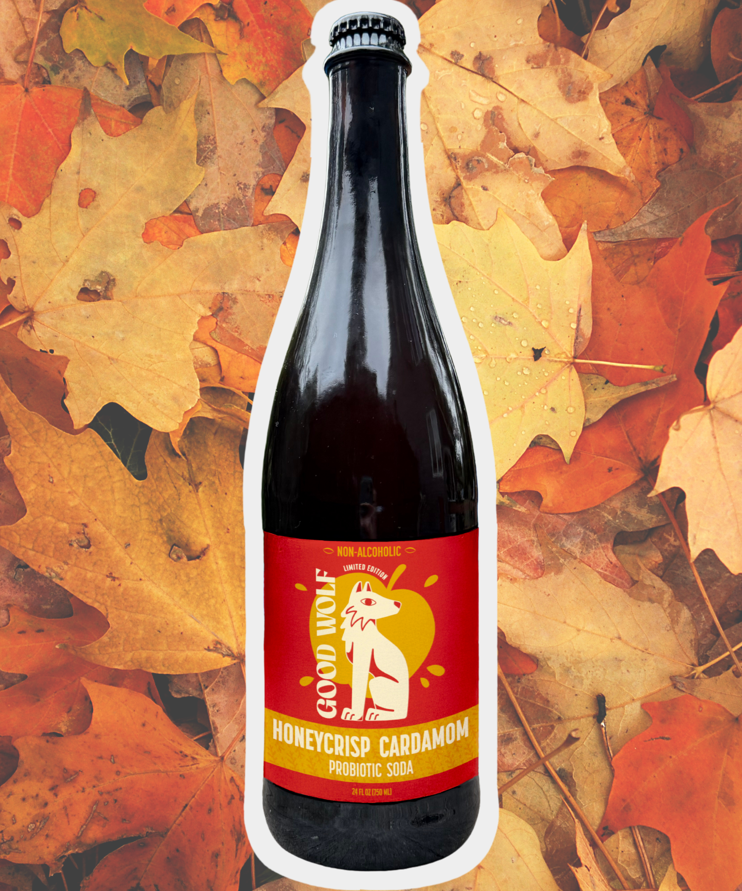750ml glass Bottle of Good Wolf Honeycrisp Cardamom soda on a background of autumn leaves